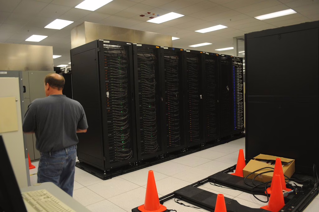 Technician standing near server racks in a data center
